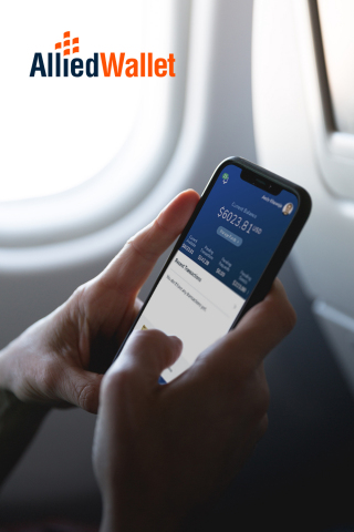 Phone displaying Allied Wallet eWallet app in front of airplane window