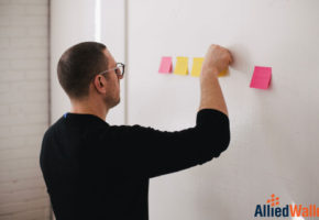 Man posting sticky notes to wall