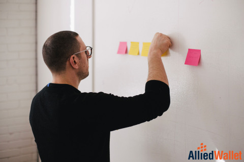 Man posting sticky notes to wall