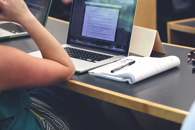 Student taking notes on laptop